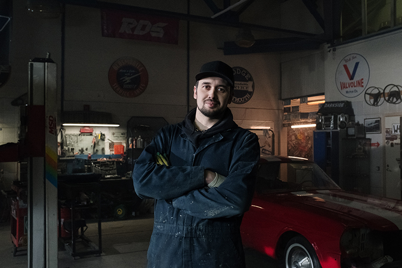 A picture of me in my repair shop smiling.